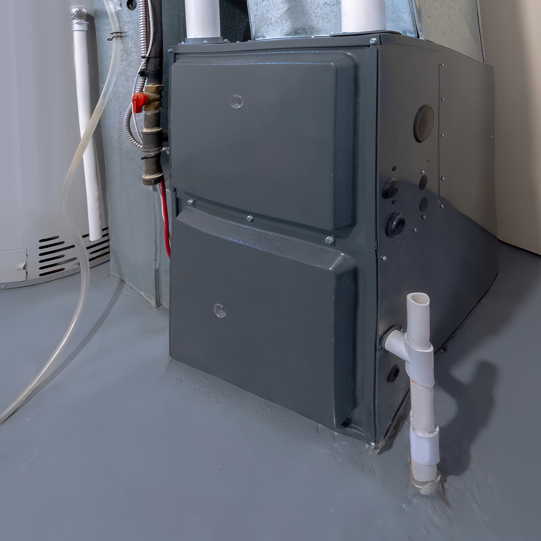 The image shows a large industrial boiler with its control panel facing forward, situated in an indoor environment with visible pipes and fittings, likely within a building s mechanical room.